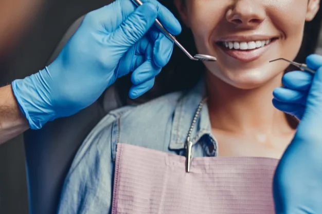 Dentista realizando atendimento em paciente sorridente